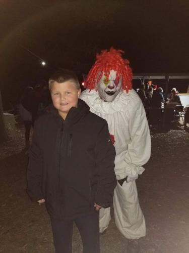 creepy-clown-posing-with-visitor-outside-haunted-woods